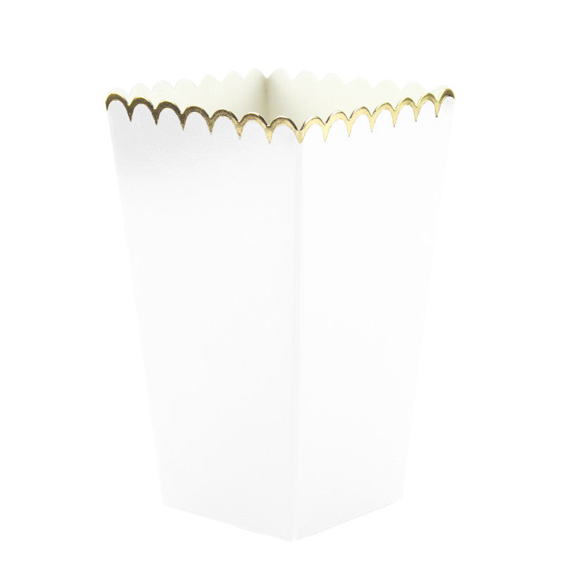 White paper treat cups with gold wavy rim on a white background