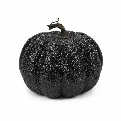 A black glittery decorative pumpkin with a dark stem, photographed against a plain white background.