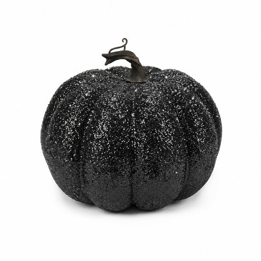 A black glittery decorative pumpkin with a dark stem, photographed against a plain white background.