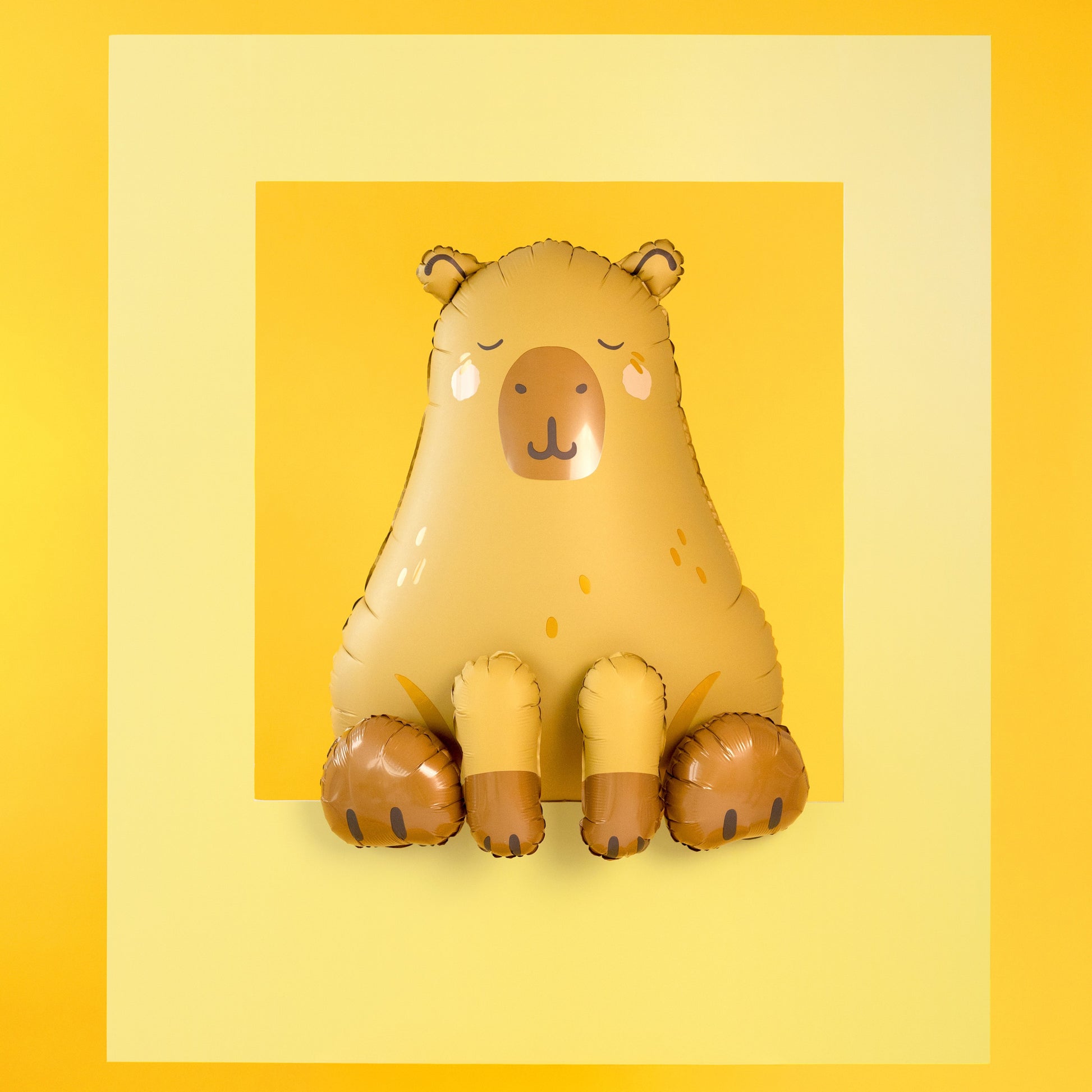 Capybara shaped foil balloon in beige and brown sitting upright