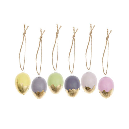 Set of pastel-colored eggs with gold accents on strings against a white background