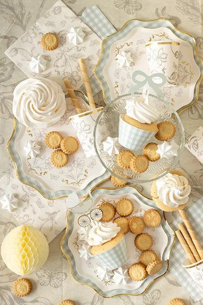 Decorative plates with cupcakes and cookies on a textured surface