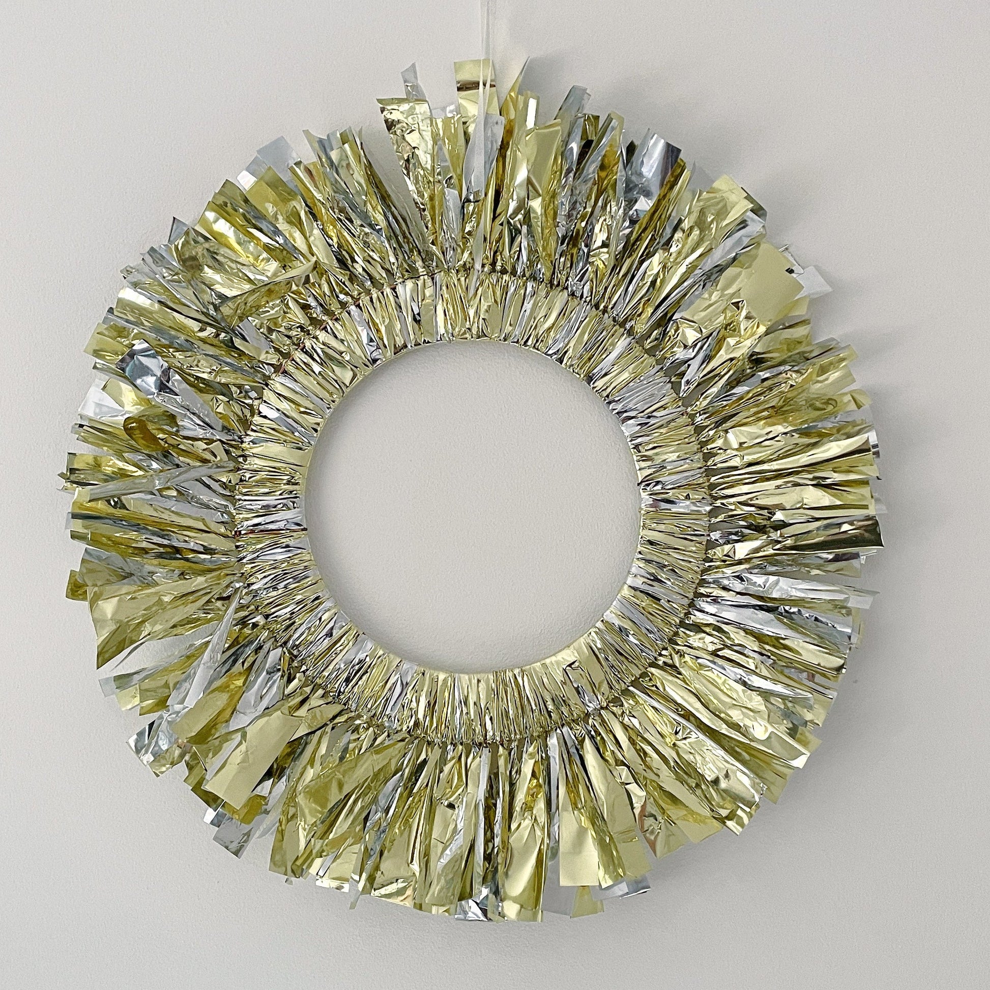 Decorative wreath with gold and silver tinsel on a plain background