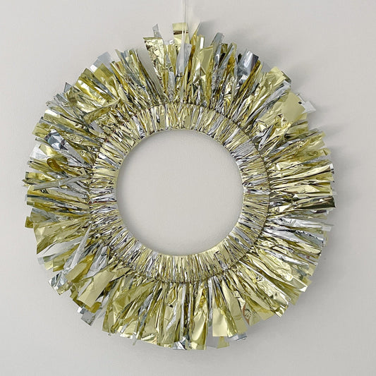 Decorative wreath with gold and silver tinsel on a plain background