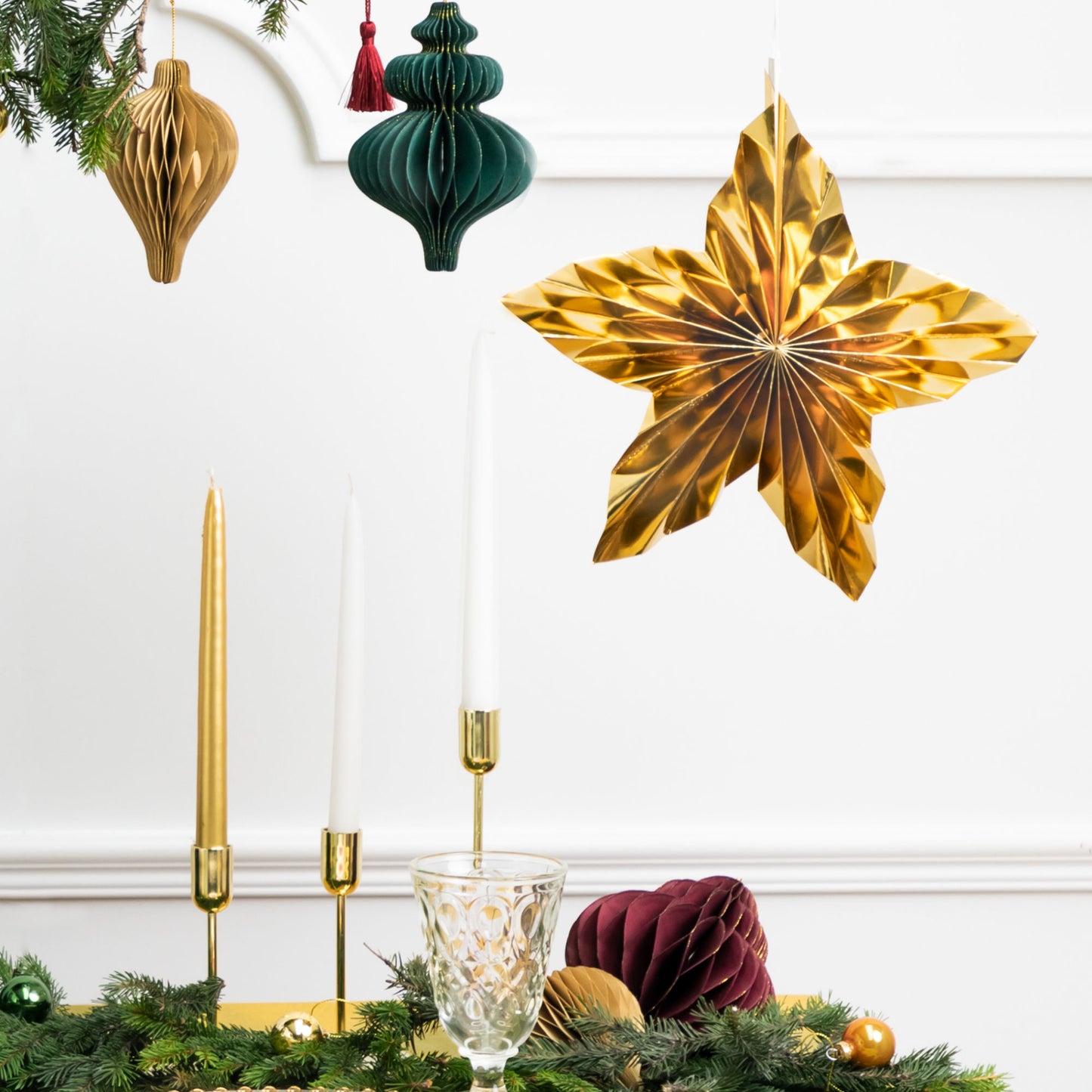 Set of 3 metallic gold hanging paper star decorations in three sizes.