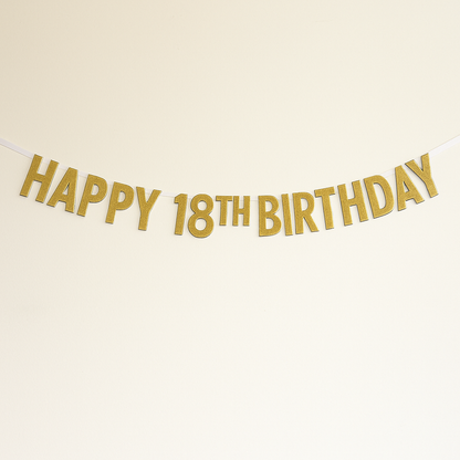 Gold metallic 'HAPPY 18TH BIRTHDAY' banner garland hanging against a plain off-white background.