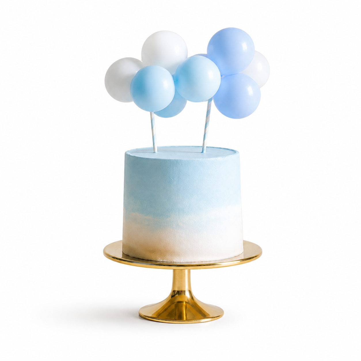 Small blue and white cake with balloon toppers on a gold stand against a white background