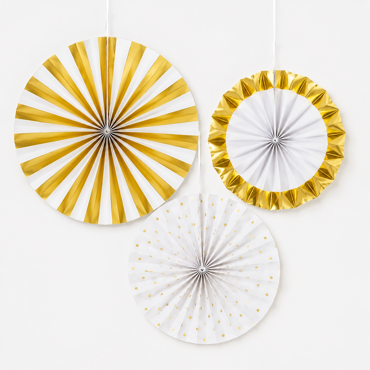 Three round hanging paper party decorations in white and metallic gold, including a striped fan, a ruffled ring, and a polka-dot fan, shown against a plain white background.