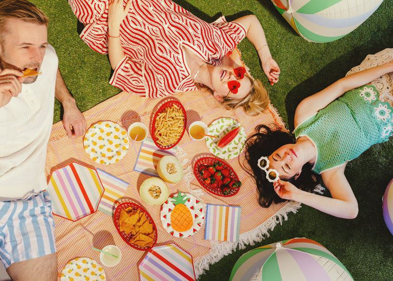 A summer picnic party setup with summer themed tableware and party supplies