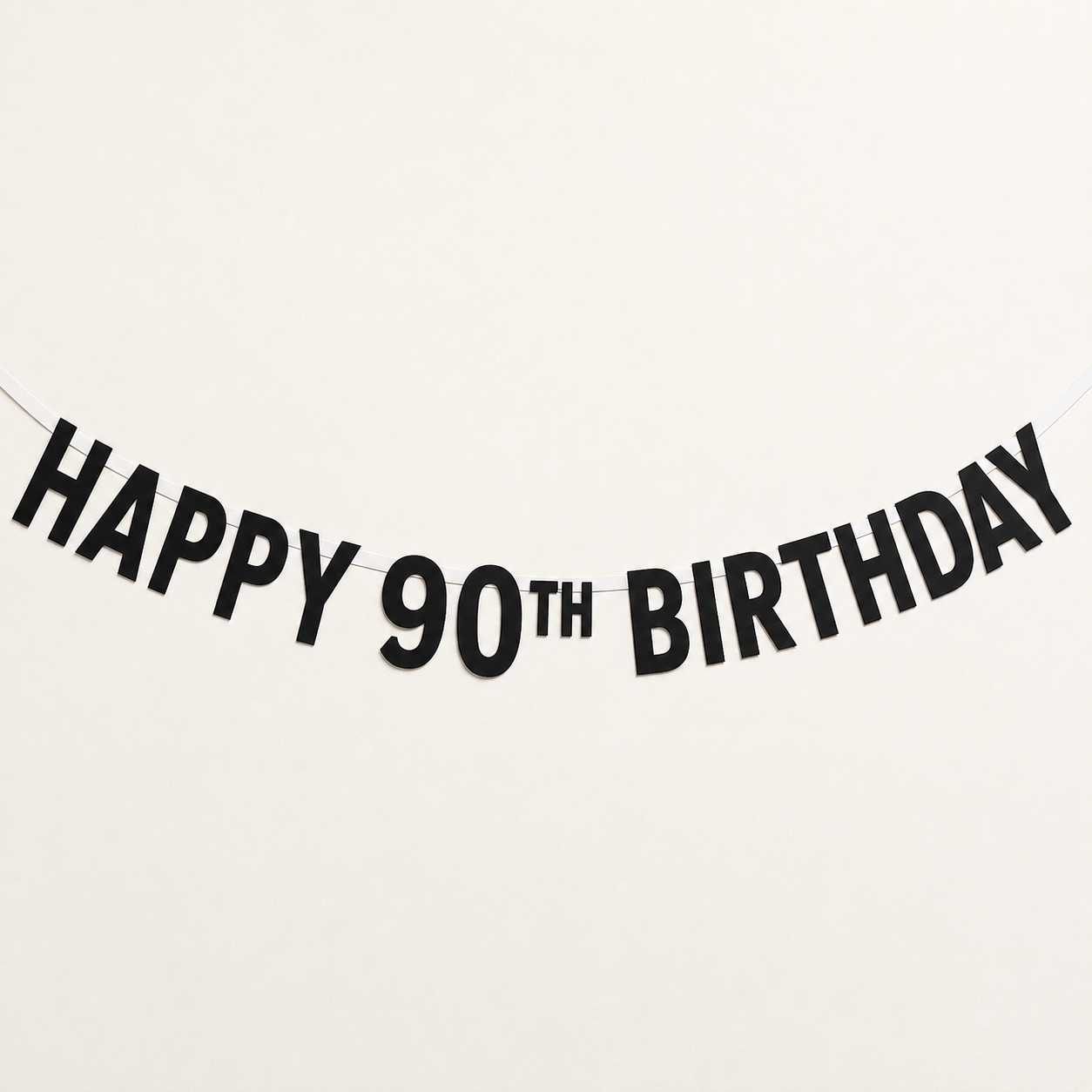 Black paper banner garland spelling 'HAPPY 90TH BIRTHDAY' on a plain white background.