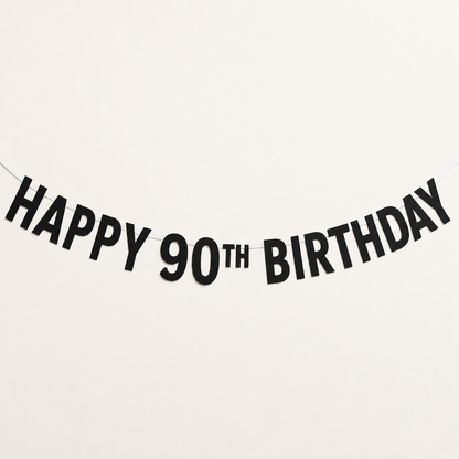 Black paper banner garland spelling 'HAPPY 90TH BIRTHDAY' on a plain white background.