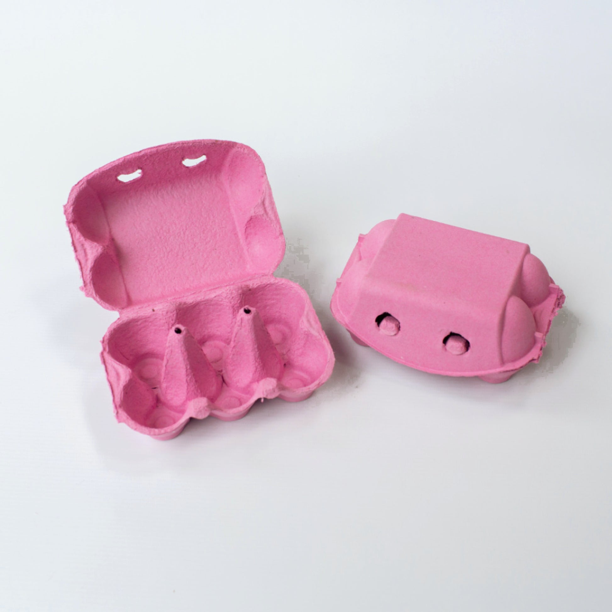 Two pink egg cartons on a white background