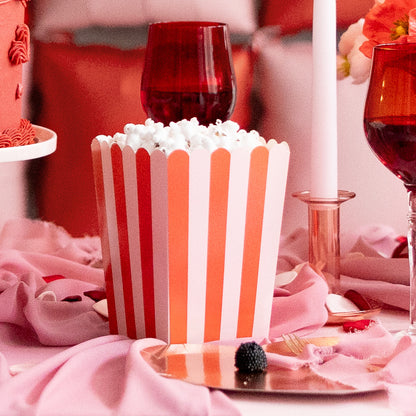 Red and pale pink striped paper popcorn box with scalloped top