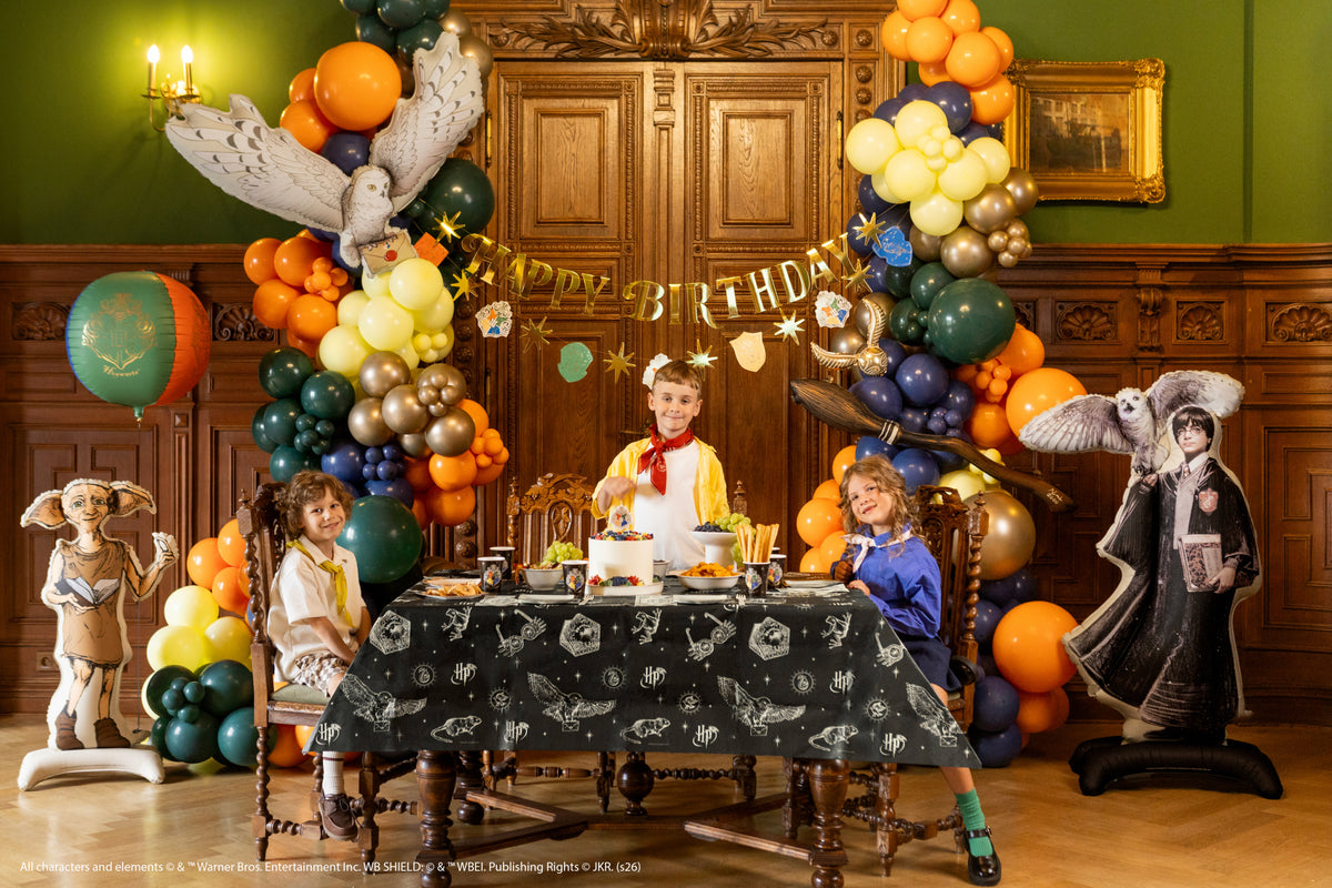 Harry Potter party table with Hedwig balloon and themed decorations
