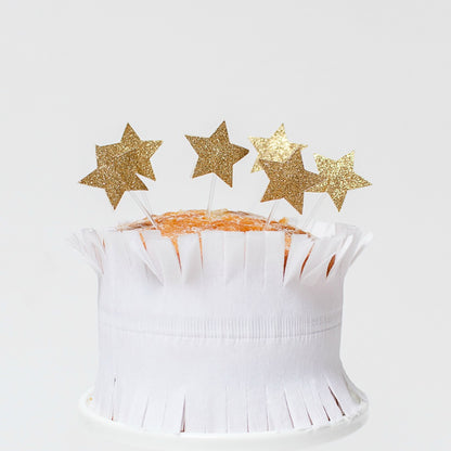 gold glitter star toppers on top of a cake.