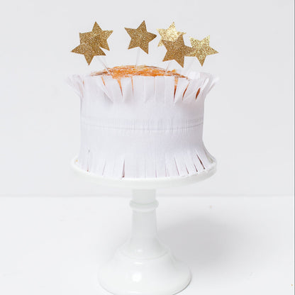 gold glitter star toppers on top of a cake.